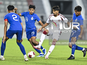 Tahsin Mohammed Jamshid (C) of Qatar battles for the ball with Sahoo Garv (2-L) of Singapore during the 2025 AFC U20 Asian Cup Qualifiers Gr...