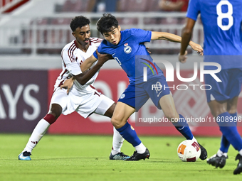 Ibrahim Mohammadali of Qatar battles for the ball with Jonan Tan of Singapore during the 2025 AFC U20 Asian Cup Qualifiers Group J match bet...