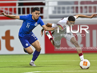 Mohamed Khaled Gouda (R) of Qatar battles for the ball with Fairuz Fazli (L) of Singapore during the 2025 AFC U20 Asian Cup Qualifiers Group...