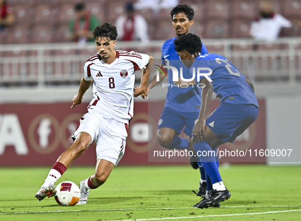 Moath Ibrahim Taha (L) of Qatar battles for the ball with Marcus Mosses (R) of Singapore during the 2025 AFC U20 Asian Cup Qualifiers Group...