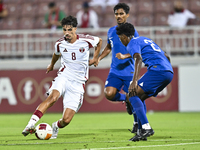 Moath Ibrahim Taha (L) of Qatar battles for the ball with Marcus Mosses (R) of Singapore during the 2025 AFC U20 Asian Cup Qualifiers Group...