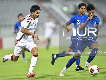 Tahsin Mohammed Jamshid (L) of Qatar battles for the ball with Raoul Suhaimi (R) of Singapore during the 2025 AFC U20 Asian Cup Qualifiers G...