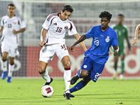 Mohamed Hani Faragalla of Qatar battles for the ball with Marcus Mosses of Singapore during the 2025 AFC U20 Asian Cup Qualifiers Group J ma...