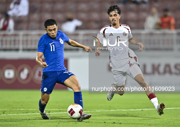 Moath Ibrahim Taha (R) of Qatar battles for the ball with Fairuz Fazli (L) of Singapore during the 2025 AFC U20 Asian Cup Qualifiers Group J...