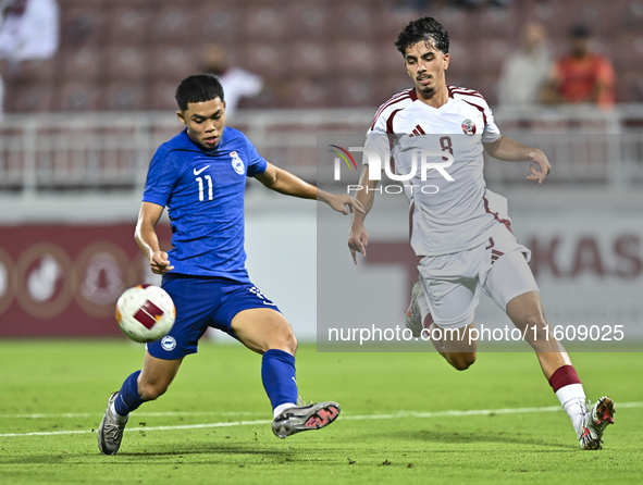 Moath Ibrahim Taha (R) of Qatar battles for the ball with Fairuz Fazli (L) of Singapore during the 2025 AFC U20 Asian Cup Qualifiers Group J...