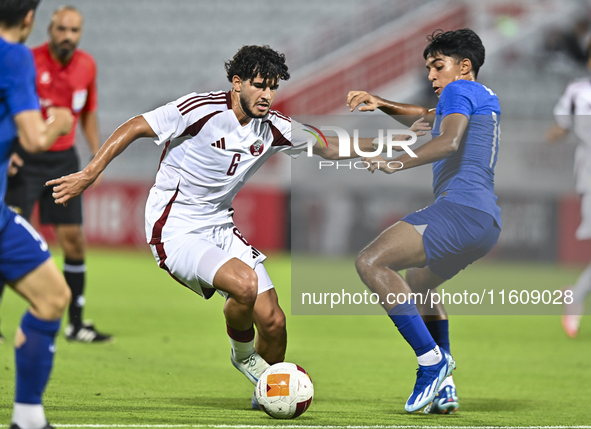 Bassam Adel Eid of Qatar battles for the ball with Sahoo Garv of Singapore during the 2025 AFC U20 Asian Cup Qualifiers Group J match betwee...