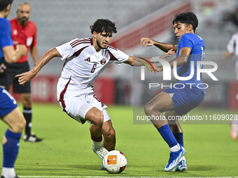 Bassam Adel Eid of Qatar battles for the ball with Sahoo Garv of Singapore during the 2025 AFC U20 Asian Cup Qualifiers Group J match betwee...