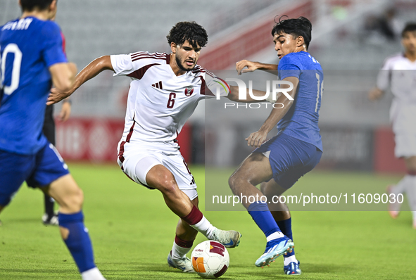 Bassam Adel Eid of Qatar battles for the ball with Sahoo Garv of Singapore during the 2025 AFC U20 Asian Cup Qualifiers Group J match betwee...