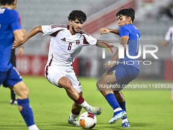 Bassam Adel Eid of Qatar battles for the ball with Sahoo Garv of Singapore during the 2025 AFC U20 Asian Cup Qualifiers Group J match betwee...