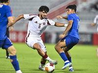 Bassam Adel Eid of Qatar battles for the ball with Sahoo Garv of Singapore during the 2025 AFC U20 Asian Cup Qualifiers Group J match betwee...