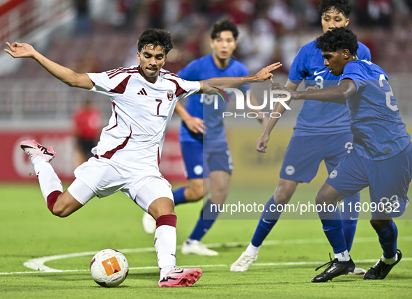 Muhammad Syazwan (L) of Qatar battles for the ball with Marcus Mosses (R) of Singapore during the 2025 AFC U20 Asian Cup Qualifiers Group J...