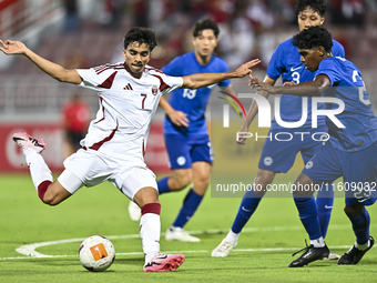 Muhammad Syazwan (L) of Qatar battles for the ball with Marcus Mosses (R) of Singapore during the 2025 AFC U20 Asian Cup Qualifiers Group J...