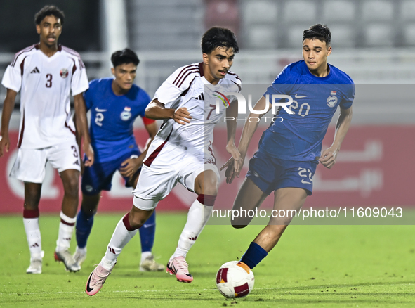 Tahsin Mohammed Jamshid (L) of Qatar battles for the ball with Iryan Fandi (R) of Singapore during the 2025 AFC U20 Asian Cup Qualifiers Gro...