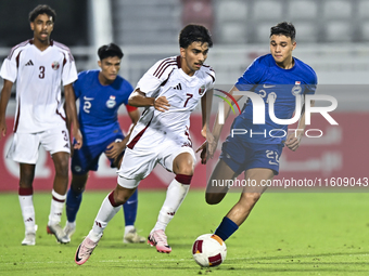 Tahsin Mohammed Jamshid (L) of Qatar battles for the ball with Iryan Fandi (R) of Singapore during the 2025 AFC U20 Asian Cup Qualifiers Gro...