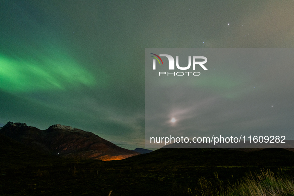 The Aurora Borealis, commonly known as the Northern Lights, are seen with the half-moon in the sky near Tromso, Norway, on September 25, 202...