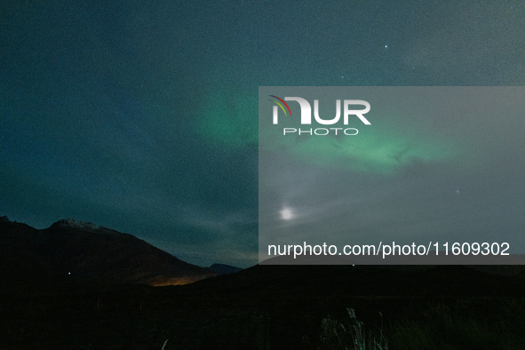 The Aurora Borealis, commonly known as the Northern Lights, are seen with the half-moon in the sky near Tromso, Norway, on September 25, 202...