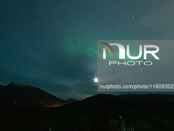 The Aurora Borealis, commonly known as the Northern Lights, are seen with the half-moon in the sky near Tromso, Norway, on September 25, 202...