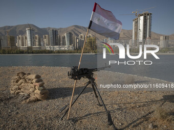 A machine gun and an Iraqi flag are placed in an area near housing complexes during the reconstruction of the Valfajr-8 military operation,...