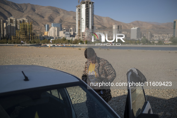 An Iranian schoolboy wears an Islamic Revolutionary Guard Corps (IRGC) military uniform while preparing to take part in a war game, which is...