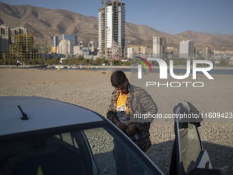 An Iranian schoolboy wears an Islamic Revolutionary Guard Corps (IRGC) military uniform while preparing to take part in a war game, which is...