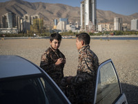 Two Iranian schoolboys wear Islamic Revolutionary Guard Corps (IRGC) military uniforms while preparing to take part in a war game, which is...