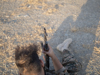 A member of the Islamic Revolutionary Guard Corps (IRGC) holds an AK-45 rifle while preparing to take part in a war game, which is a reconst...