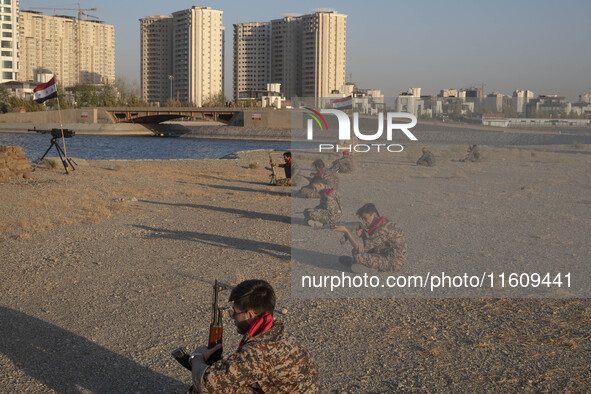 Members of the Islamic Revolutionary Guard Corps (IRGC) hold AK-45 rifles while preparing to take part in a war game, which is a reconstruct...