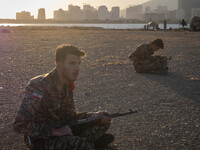 Two members of the Islamic Revolutionary Guard Corps (IRGC) hold AK-45 rifles while preparing to take part in a war game, which is a reconst...