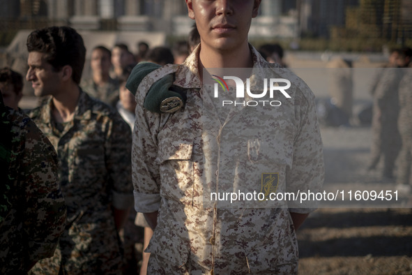 An Islamic Revolutionary Guard Corps (IRGC) military personnel stands at attention during the reconstruction of the Valfajr-8 military opera...