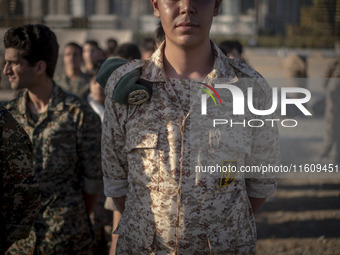 An Islamic Revolutionary Guard Corps (IRGC) military personnel stands at attention during the reconstruction of the Valfajr-8 military opera...