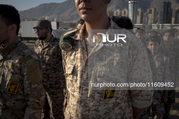 Islamic Revolutionary Guard Corps (IRGC) military personnel stand at attention during the reconstruction of the Valfajr-8 military operation...