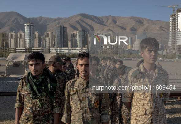 Islamic Revolutionary Guard Corps (IRGC) military personnel stand at attention during the reconstruction of the Valfajr-8 military operation...