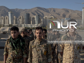 Islamic Revolutionary Guard Corps (IRGC) military personnel stand at attention during the reconstruction of the Valfajr-8 military operation...