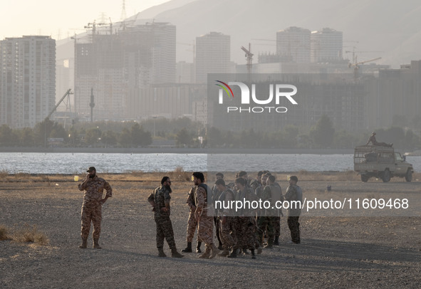 Islamic Revolutionary Guard Corps (IRGC) military personnel stand in an area while preparing to take part in a war game, which is a reconstr...