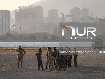 Islamic Revolutionary Guard Corps (IRGC) military personnel stand in an area while preparing to take part in a war game, which is a reconstr...