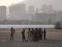 Islamic Revolutionary Guard Corps (IRGC) military personnel stand in an area while preparing to take part in a war game, which is a reconstr...