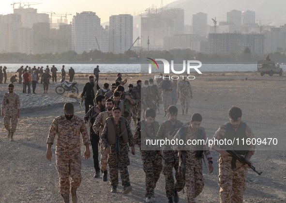 Islamic Revolutionary Guard Corps (IRGC) military personnel walk along an area during a war-game, which is a reconstruction of the Valfajr-8...