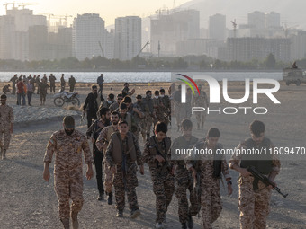 Islamic Revolutionary Guard Corps (IRGC) military personnel walk along an area during a war-game, which is a reconstruction of the Valfajr-8...