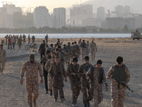 Islamic Revolutionary Guard Corps (IRGC) military personnel walk along an area during a war-game, which is a reconstruction of the Valfajr-8...