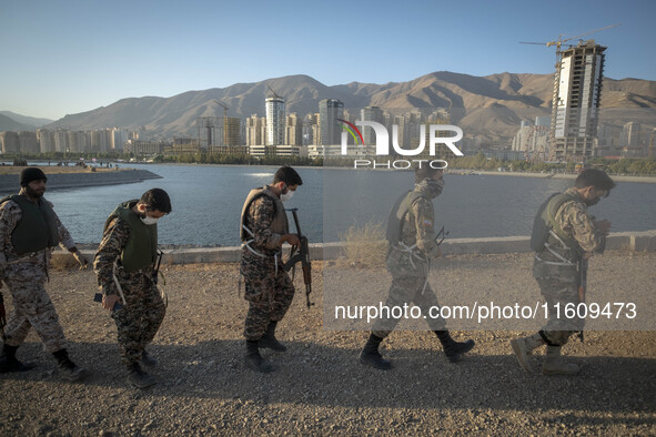 Islamic Revolutionary Guard Corps (IRGC) military personnel walk along an area during a war-game, which is a reconstruction of the Valfajr-8...