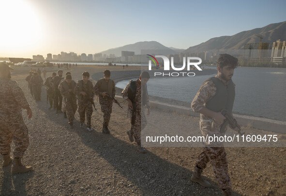 Islamic Revolutionary Guard Corps (IRGC) military personnel walk along an area during a war-game, which is a reconstruction of the Valfajr-8...