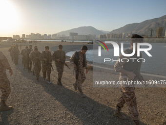 Islamic Revolutionary Guard Corps (IRGC) military personnel walk along an area during a war-game, which is a reconstruction of the Valfajr-8...