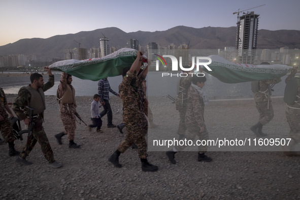 Islamic Revolutionary Guard Corps (IRGC) military personnel carry symbolic figures of Iranian warriors covered with Iranian flags during a w...