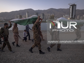 Islamic Revolutionary Guard Corps (IRGC) military personnel carry symbolic figures of Iranian warriors covered with Iranian flags during a w...