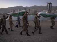 Islamic Revolutionary Guard Corps (IRGC) military personnel carry symbolic figures of Iranian warriors covered with Iranian flags during a w...