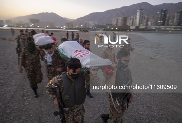 Islamic Revolutionary Guard Corps (IRGC) military personnel carry symbolic figures of Iranian warriors covered with Iranian flags during a w...