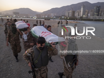 Islamic Revolutionary Guard Corps (IRGC) military personnel carry symbolic figures of Iranian warriors covered with Iranian flags during a w...