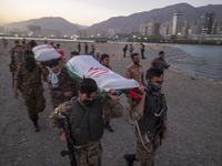 Islamic Revolutionary Guard Corps (IRGC) military personnel carry symbolic figures of Iranian warriors covered with Iranian flags during a w...