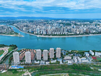 An aerial view shows high-rise buildings lining the riverside city, half landscape and half city, in Yichang, Hubei, China, on September 21,...