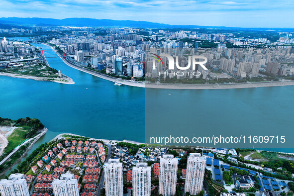 An aerial view shows high-rise buildings lining the riverside city, half landscape and half city, in Yichang, Hubei, China, on September 21,...